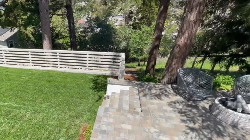 Finished backyard paver patio next to a fresh green lawn