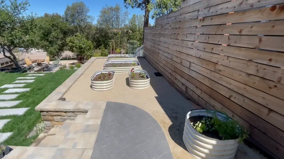 Concrete walkway with stepping pads beside a horizontal wood fence