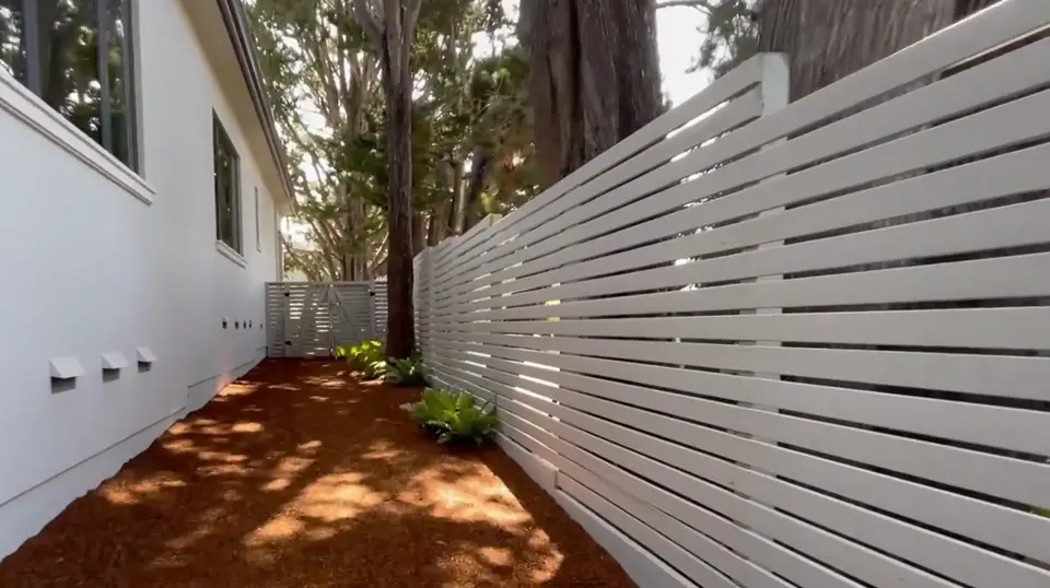 Finished side yard path with clean edges along a modern fence